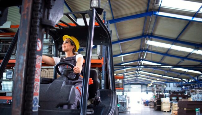 Directrices para una eficaz coordinación de actividades empresariales una mujer conduce una carretilla mecánica en una planta logística